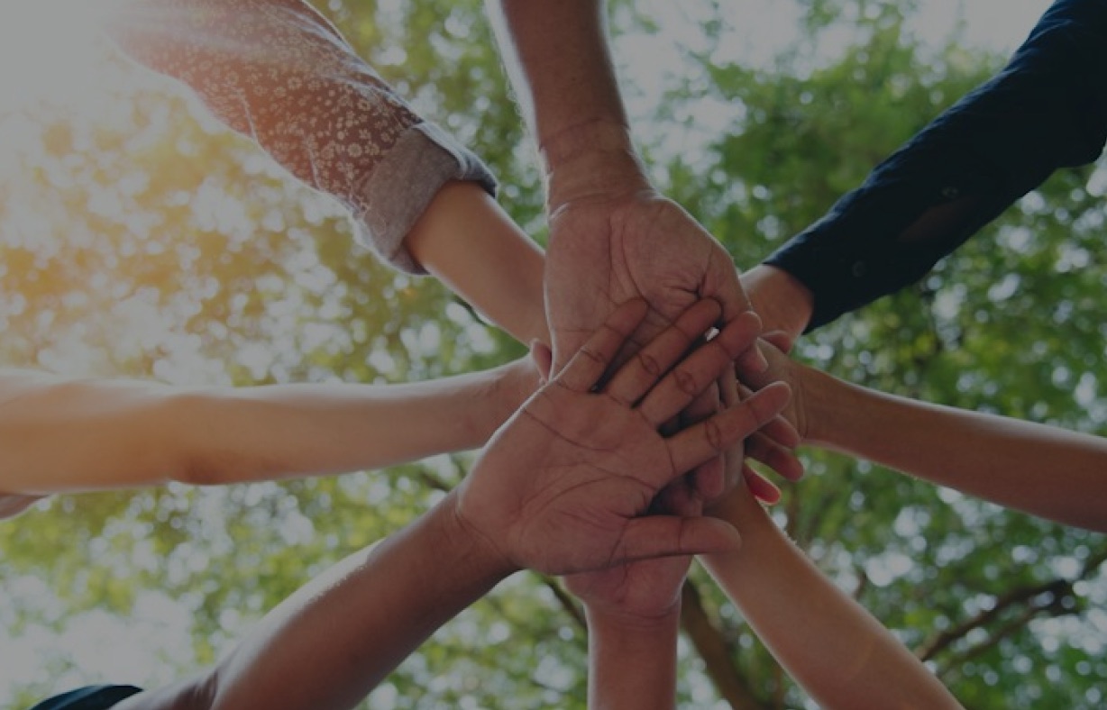 Many hands joined together in a circle