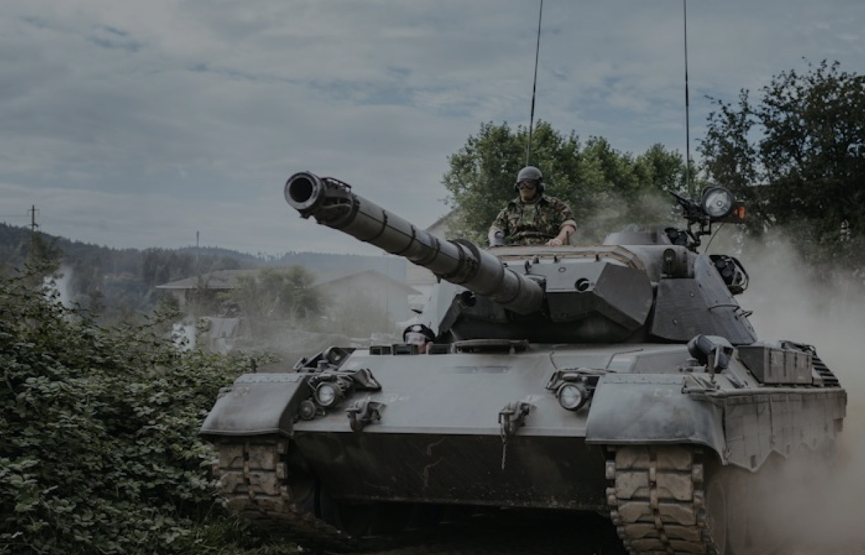 An armoured vehicle moving along a dirt road